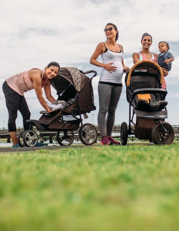 Pregnant friends with their babies enjoying outside
