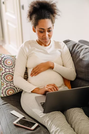 pregnant-woman-on-couch-using-laptop