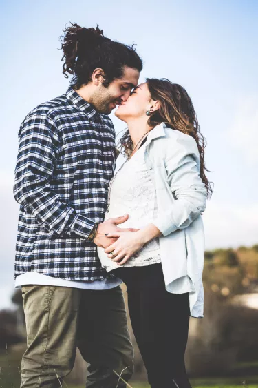man-pregnant-woman-kiss-outside
