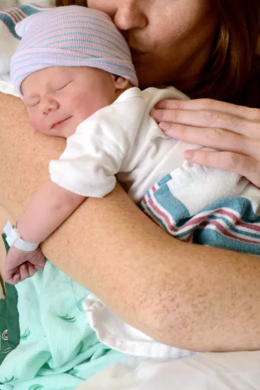 mom-kissing-smiling-newborn-in-hospital