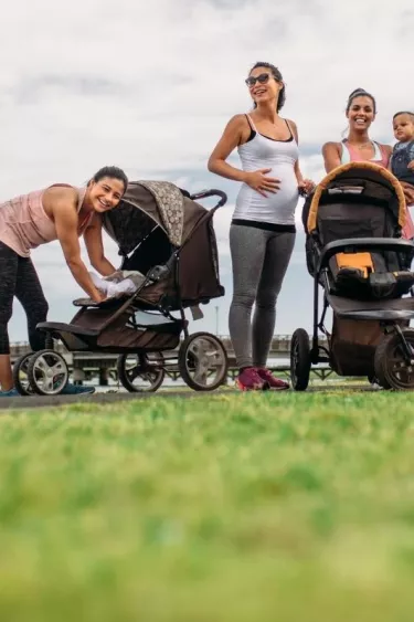 Pregnant friends with their babies enjoying outside