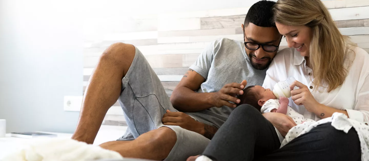 parents-feeding-newborn-bottle-in-bed