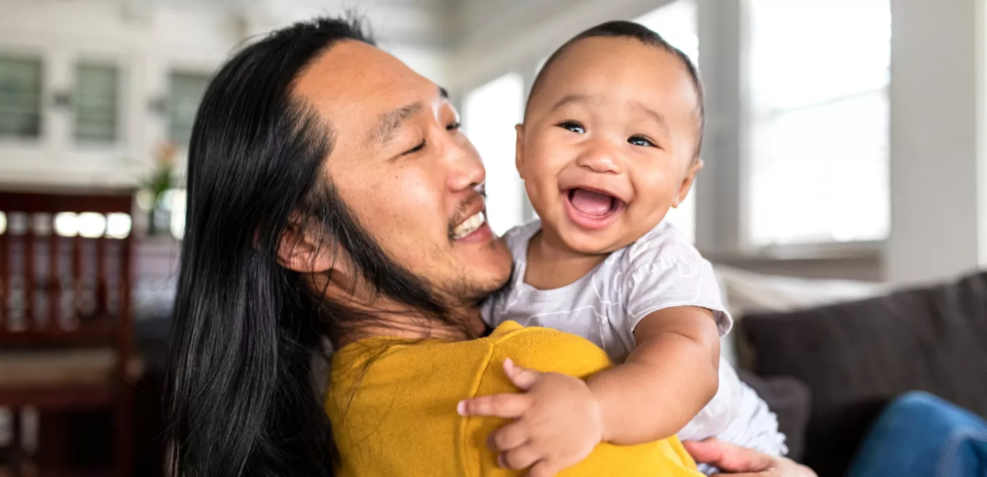 baby-laughing-over-dads-shoulder