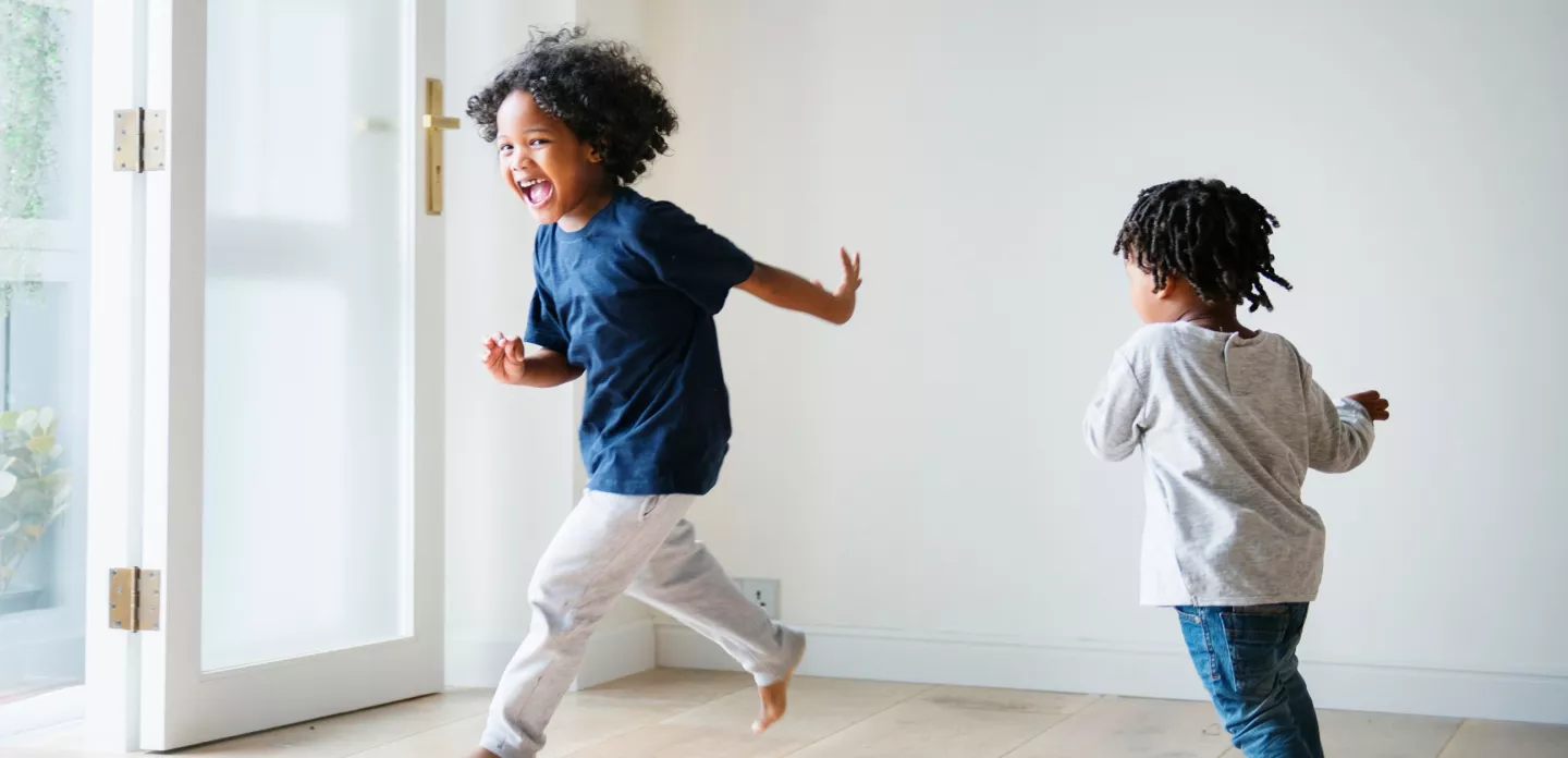 two-young-bothers-chase-each-other-in-house