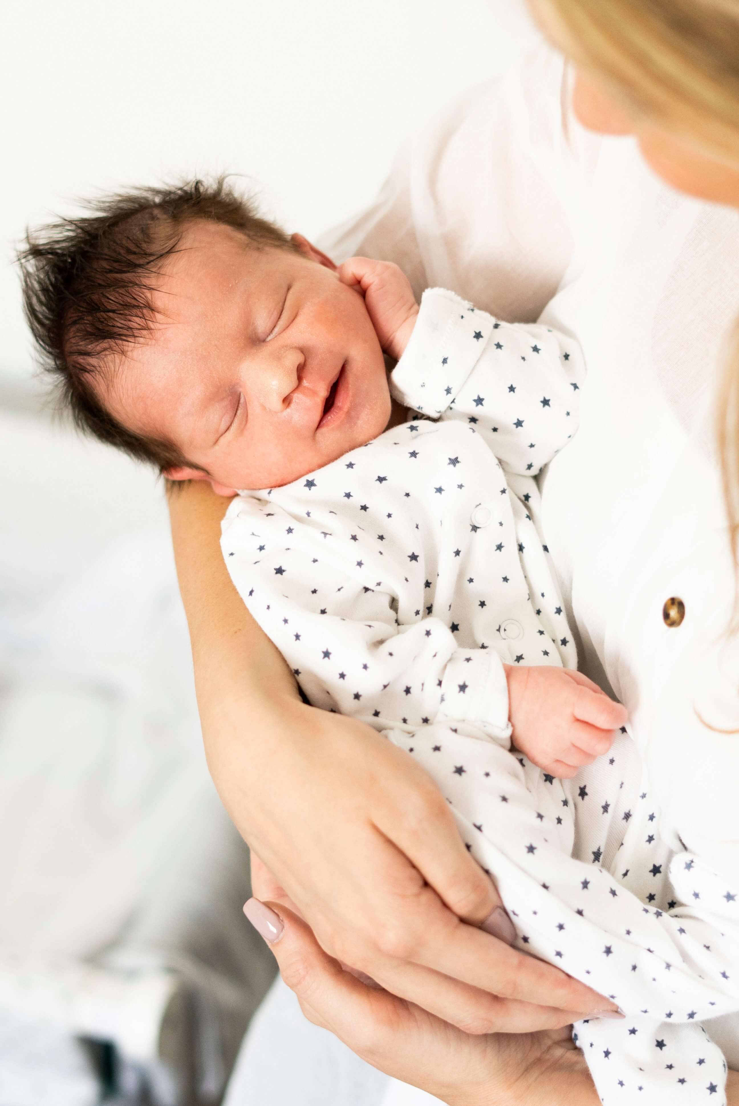 Newborn sleeping peacefully in mother's arms